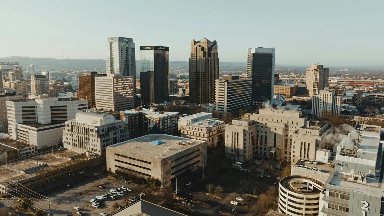The downtown Birmingham, Alabama skyline from above in early morning light, with office towers rising over the city center
