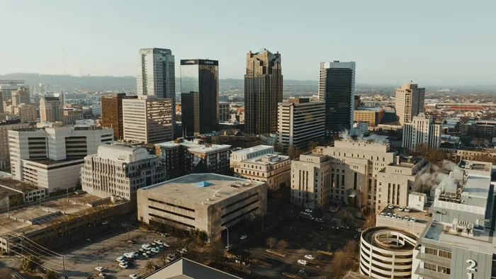 The downtown Birmingham, Alabama skyline from above in early morning light, with office towers rising over the city center