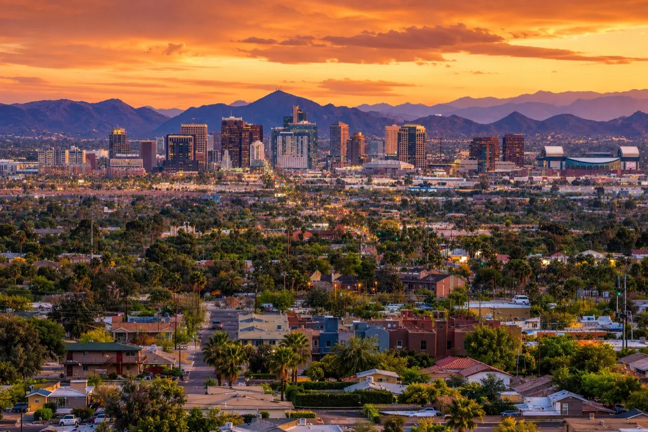 Phoenix, Arizona skyline at sunset with mountains and residential neighborhoods in the foreground