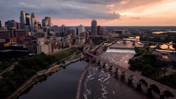 The Stone Arch Bridge and St. Anthony Falls on the Mississippi River below the downtown Minneapolis, Minnesota skyline at sunset